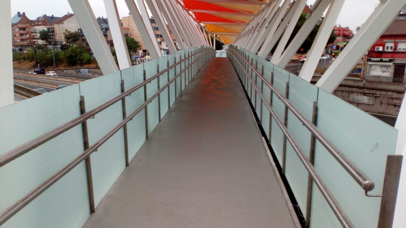 Una pasarela muy larga con barandilla de acero inoxidable.