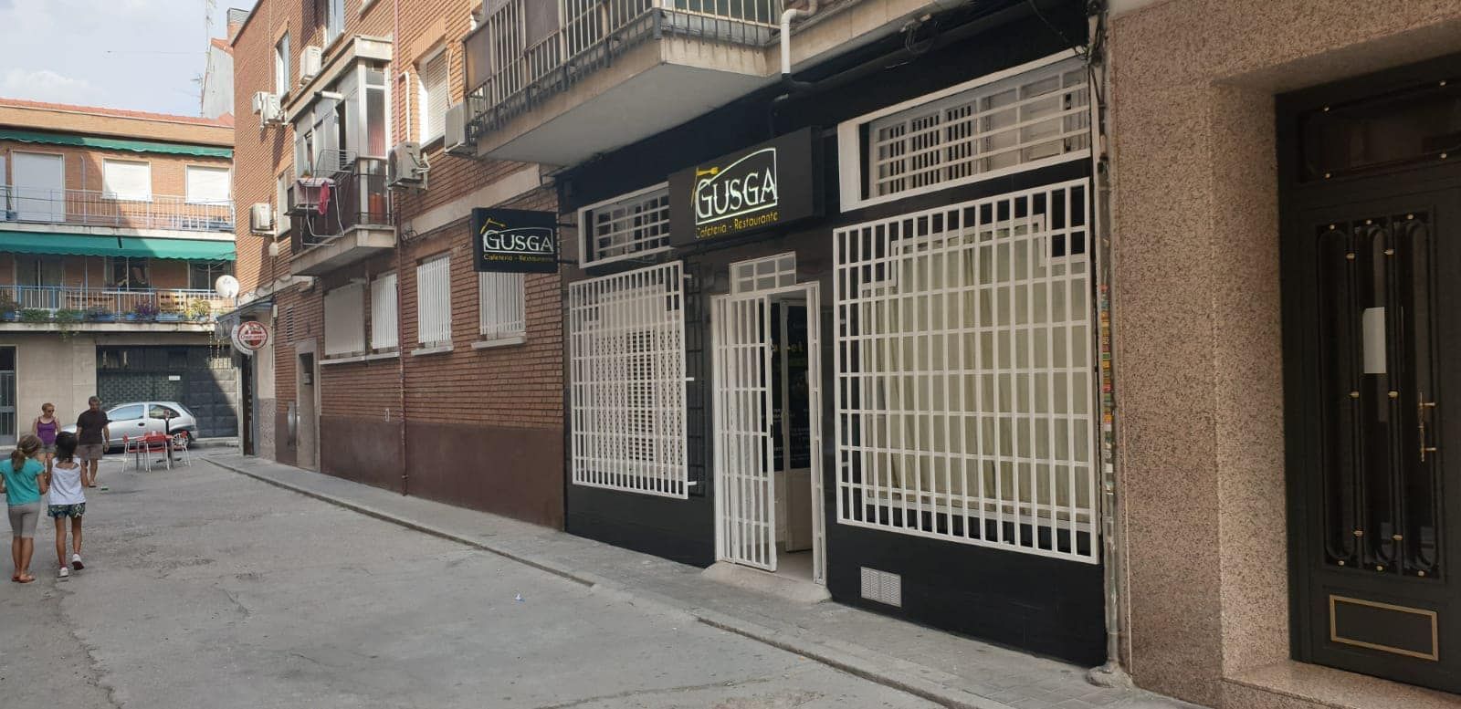 Un grupo de personas camina por una calle frente a un edificio.