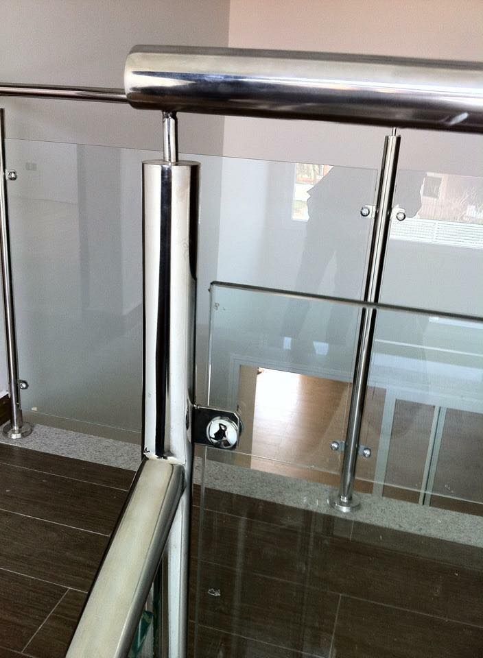 Una escalera con barandilla de cristal y barandilla de acero inoxidable.