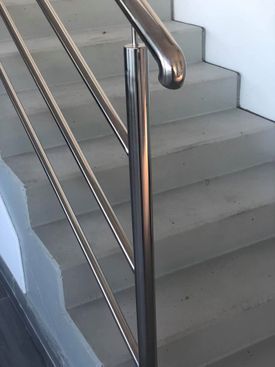 Un primer plano de una barandilla de acero inoxidable en un conjunto de escaleras.