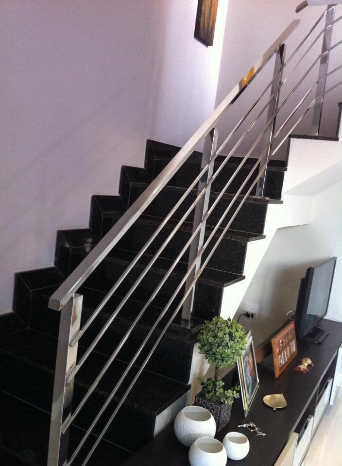 Una escalera con barandilla de acero inoxidable en una sala de estar.