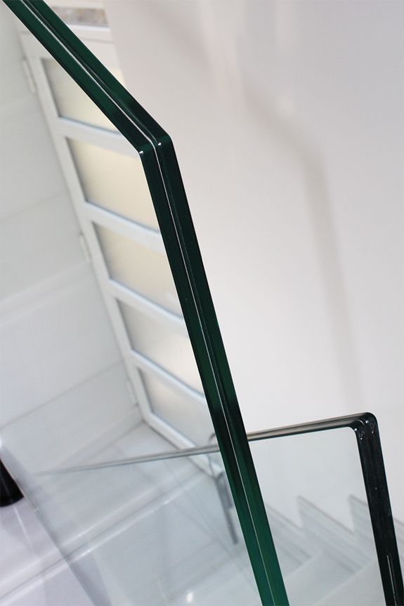 Un primer plano de una barandilla de vidrio en una escalera.