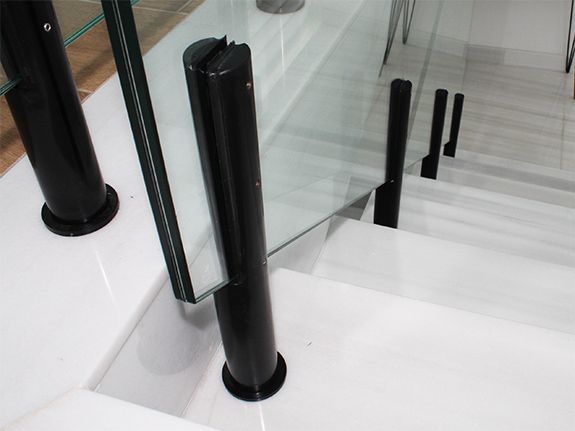 Un primer plano de una barandilla de vidrio en una escalera.