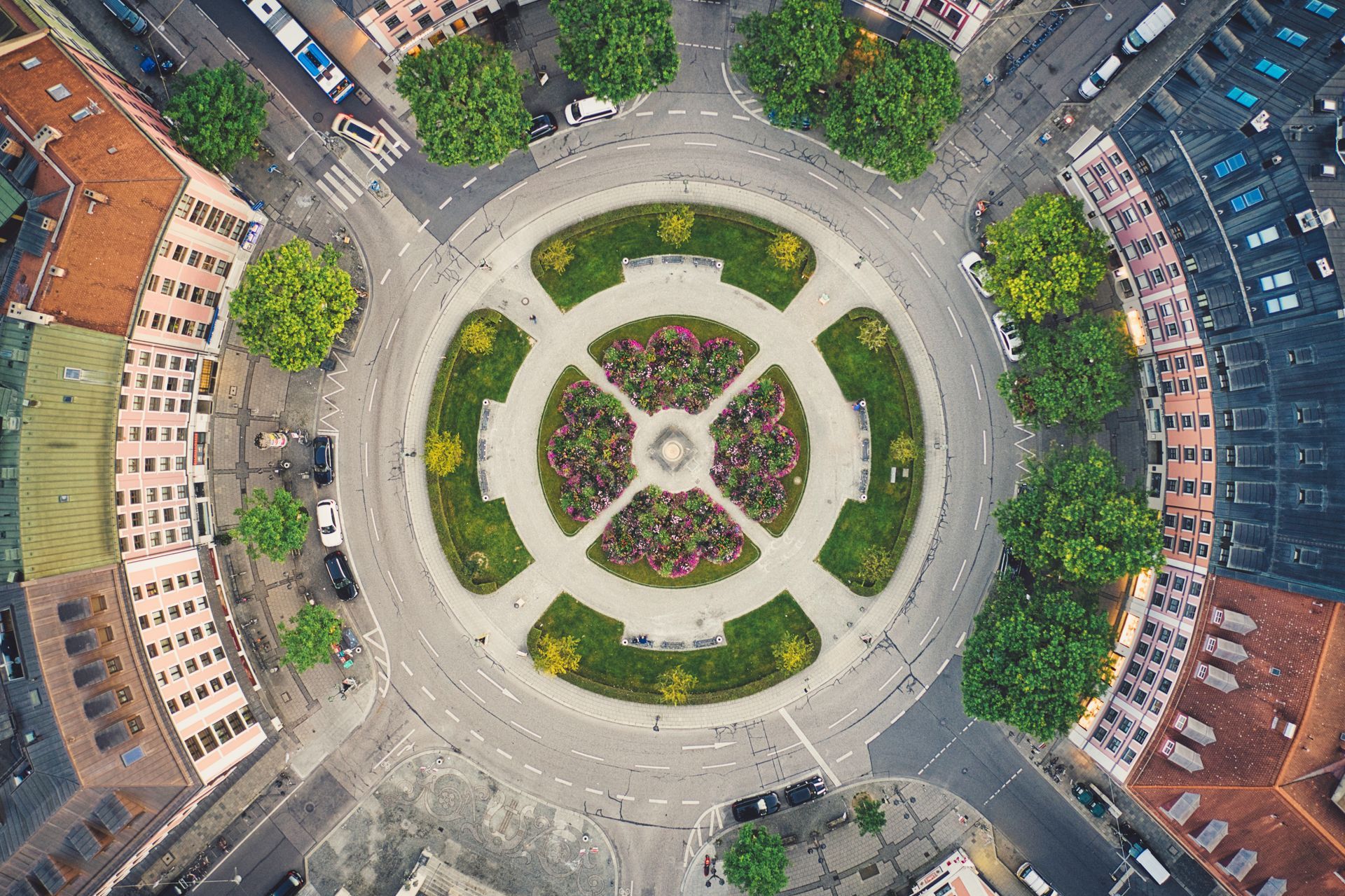 Vue aérienne d'un rond-point circulaire avec un jardin central divisé en quatre sections par des allées piétonnes.