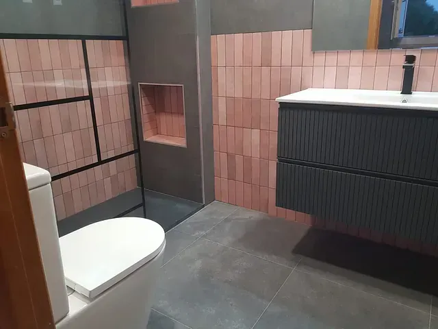 Un baño con inodoro, lavabo y ducha.