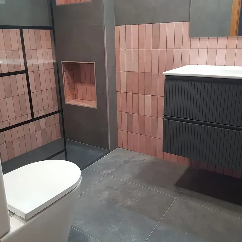 Un baño con inodoro, lavabo y ducha.