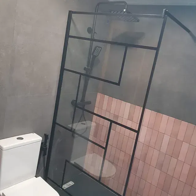 Un baño con inodoro, ducha y cabezal de ducha.