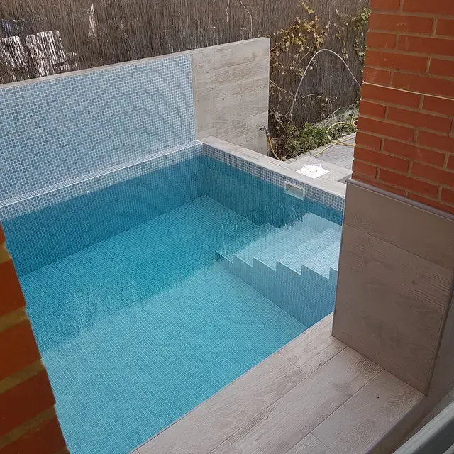 Una pequeña piscina con escaleras que conducen a ella.