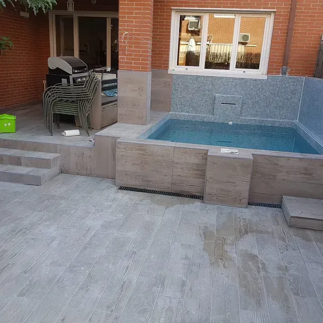 Un edificio de ladrillo con una piscina enfrente.