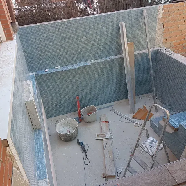 Un cubo de cemento está en el suelo al lado de una escalera.