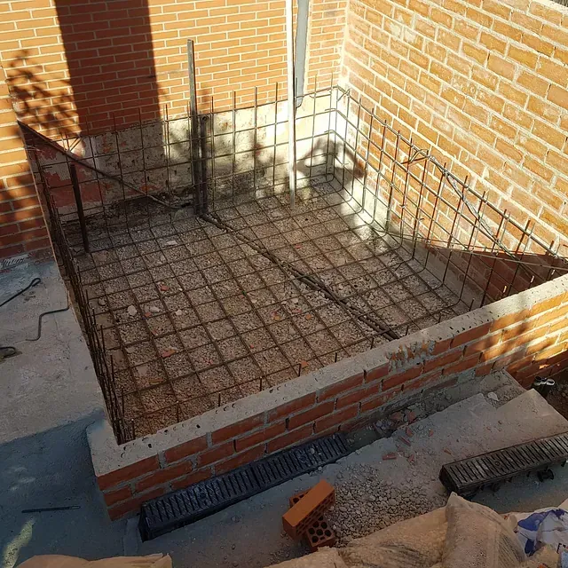 Se está construyendo un muro de ladrillos con una valla metálica a su alrededor.