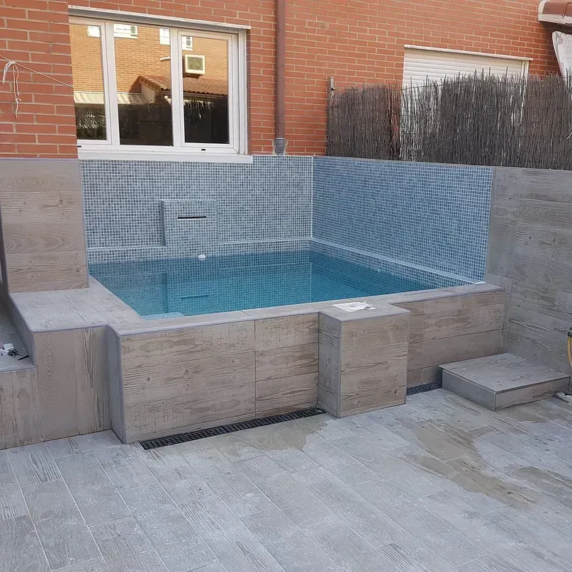 Una gran piscina frente a un edificio de ladrillo.