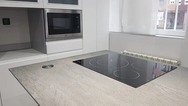 Una cocina con estufa, horno y microondas.