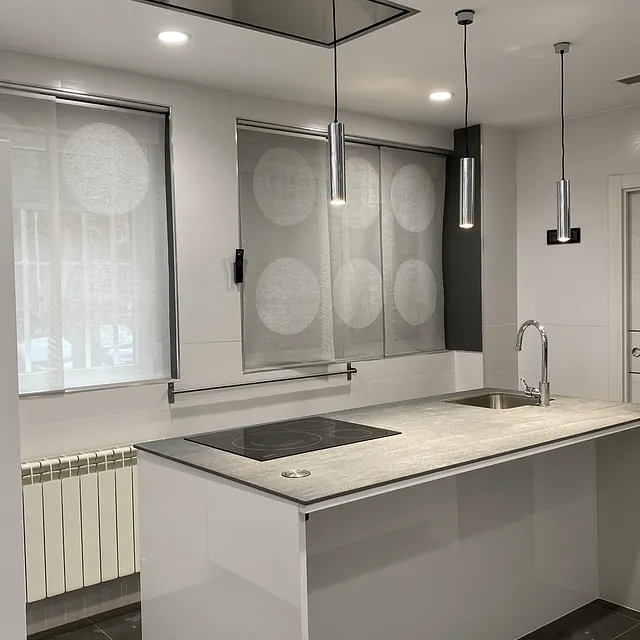 Una cocina con una gran isla y un fregadero.