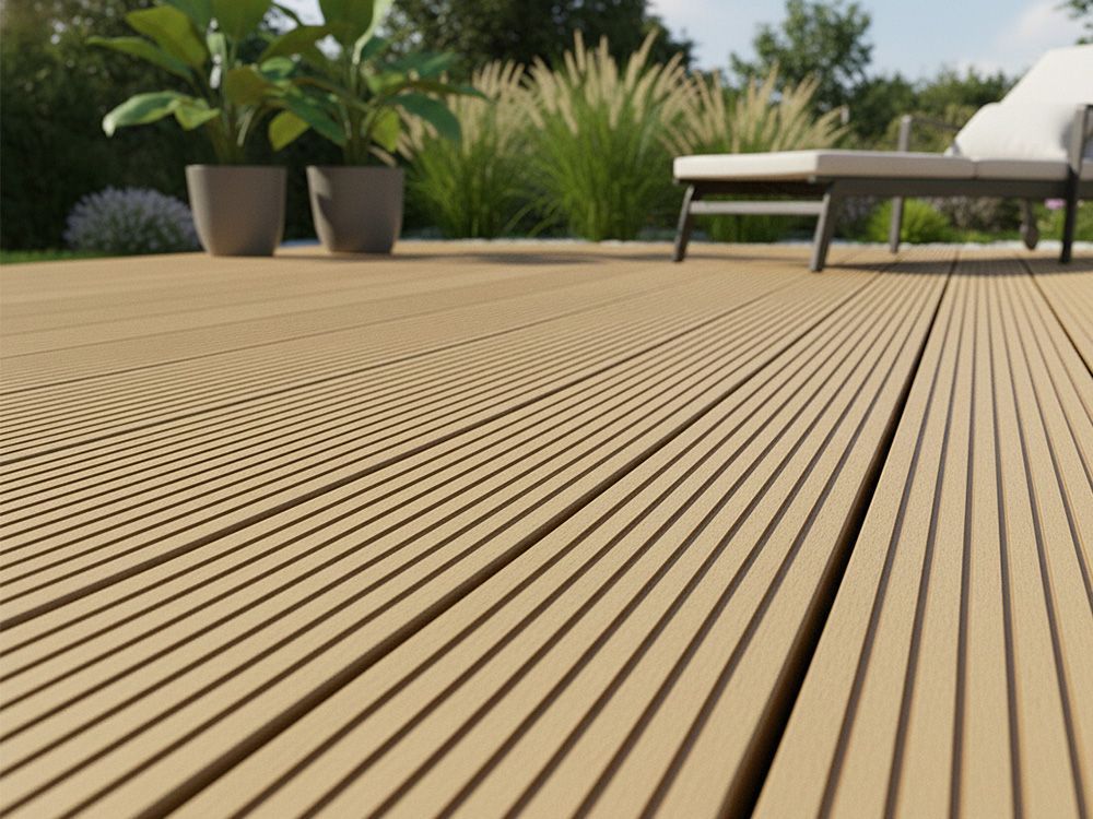 Nahaufnahme einer hellbraunen, gerillten Komposit-Terrasse mit Gartenmöbeln und Pflanzen im Hintergrund.