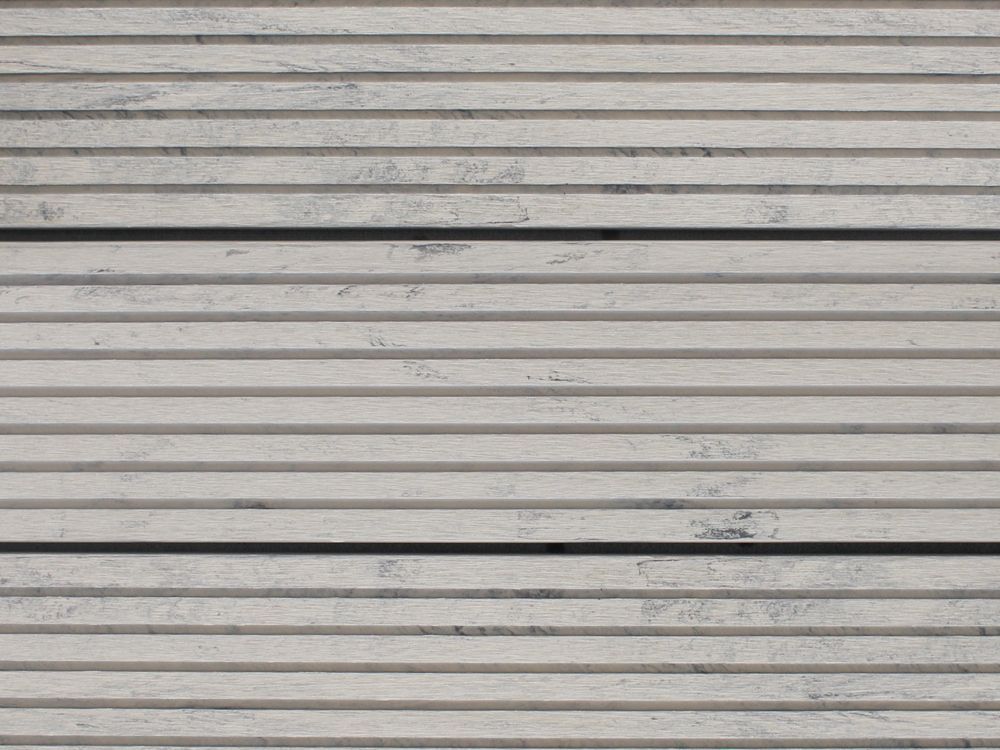 Horizontal strukturierte Betonplatten, cremeweiß mit feinen, parallelen Rillen und dunkleren grauen Linien.