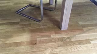 Ein Holztisch und Stühle stehen auf einem Holzboden.