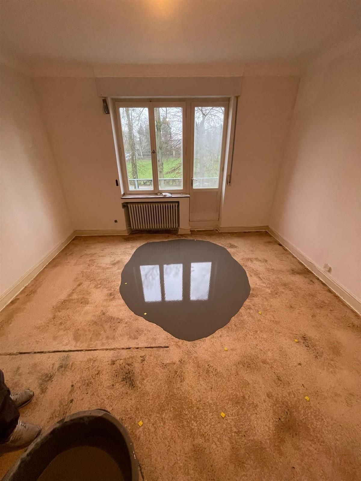 Ein Raum mit einem Loch im Boden und einem Fenster.