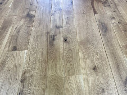 Ein Raum mit Holzboden und weißen Zierleisten.