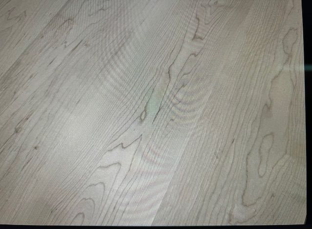 Eine Nahaufnahme eines Holzbodens in einem Raum.