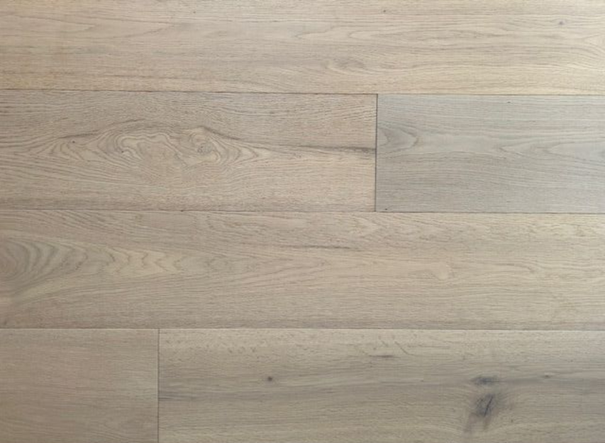 Ein Raum mit Holzboden und weißen Zierleisten.