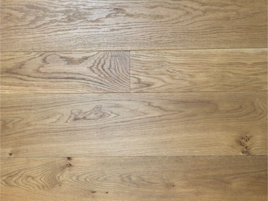 Ein Raum mit Holzboden und weißen Zierleisten.