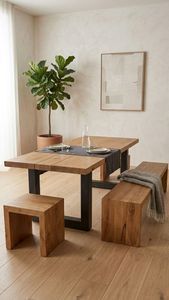 Ein langer Esstisch aus Holz mit Tellern, Gläsern und Kerzen in einem hellen, modernen Zimmer