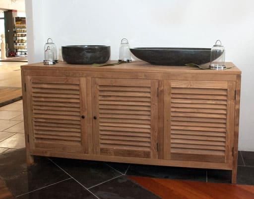 Ein Holzschrank mit zwei Waschbecken darauf.