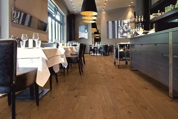 Ein Restaurant mit Holzböden und Tischen und Stühlen