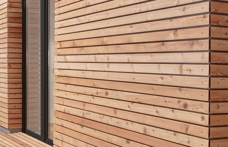 Eine Nahaufnahme einer Holzwand mit einem Fenster.