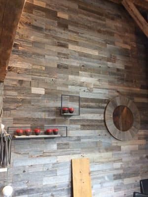 Eine Holzwand mit einem Regal und einer Uhr darauf.