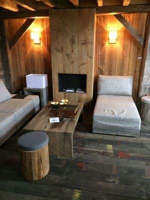 Ein Wohnzimmer mit Couch, Sessel, Couchtisch und Kamin.