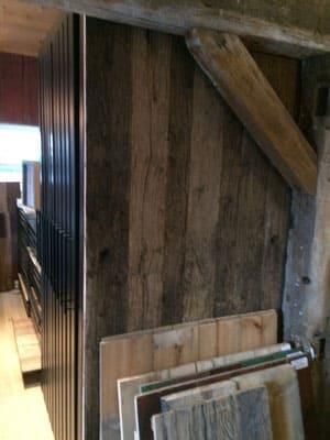 Ein Raum mit einer Holzwand und einem Stapel Holzbretter.