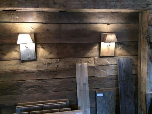 Ein Raum mit einer Holzwand und zwei Lampen daran.