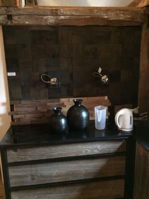 Ein Tisch mit Vasen und einem Wasserkocher darauf in einem Zimmer.