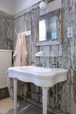 Ein Badezimmer mit Waschbecken, Spiegel und Heizkörper.