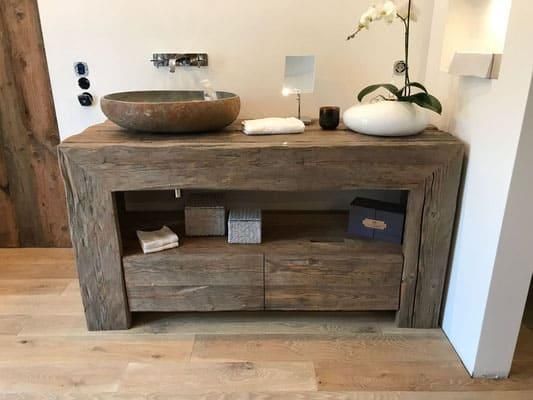 Ein Badezimmer mit einem Holzwaschtisch und einem Steinwaschbecken.