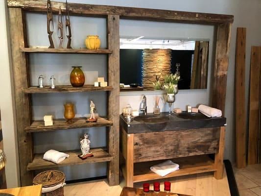 Ein Badezimmer mit zwei Waschbecken, einem Spiegel und einem Holzregal.