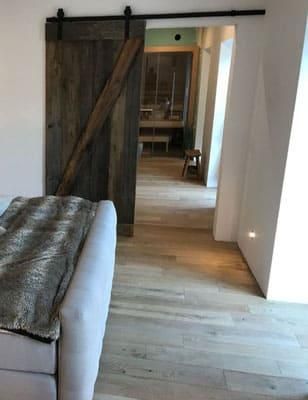 Ein Wohnzimmer mit einer Couch und einer Schiebetür, die zu einem Badezimmer führt.