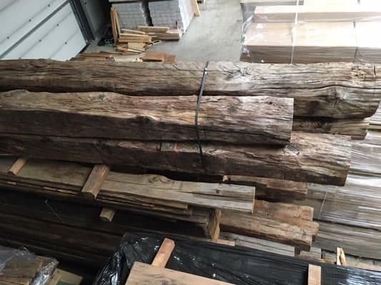 Ein Stapel übereinander gestapelter Holzbalken in einer Lagerhalle.