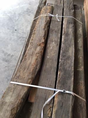 Ein Bündel Holzbretter, die mit einem weißen Seil zusammengebunden sind.