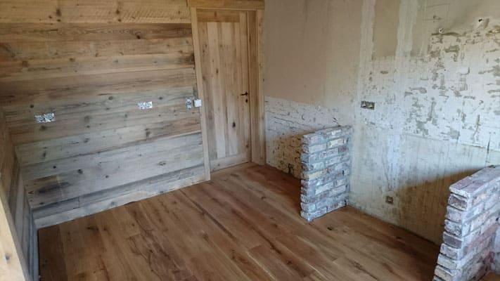 Ein Raum mit Holzboden und Ziegelwand.