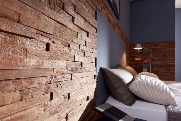 Ein Schlafzimmer mit einem Bett und einer Holzwand
