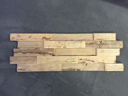 Ein Stück Holz liegt auf einer schwarzen Oberfläche.