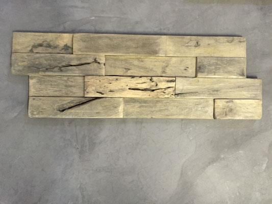Ein Stück Holz liegt auf einer Betonoberfläche.