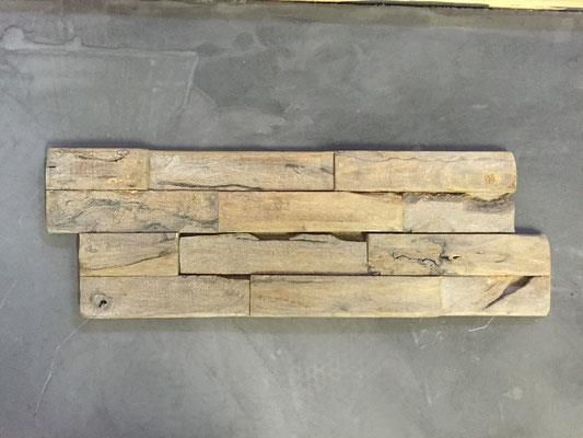 Ein Stück Holz liegt auf einer grauen Oberfläche.