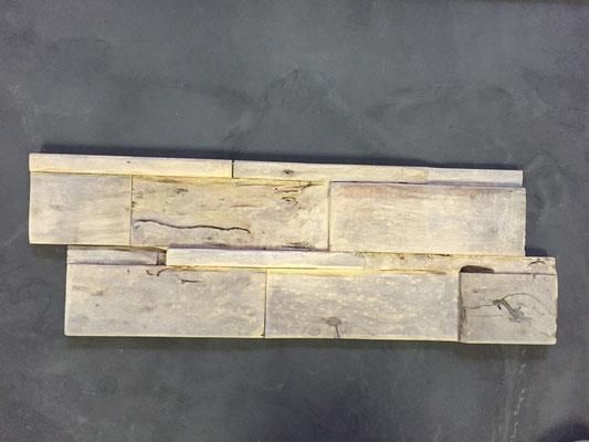 Ein Stück Holz liegt auf einer schwarzen Oberfläche.