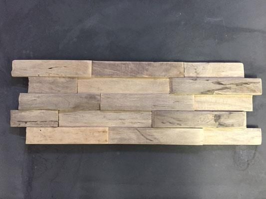 Ein Stück Holz liegt auf einer schwarzen Oberfläche.
