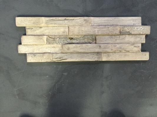 Ein Stück Holz liegt auf einer schwarzen Oberfläche.