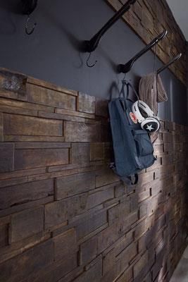 An einer Holzwand hängt ein Rucksack.